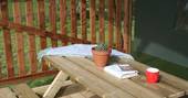 Relaxing wooden bench area outside of the Safari tent with blanket and books