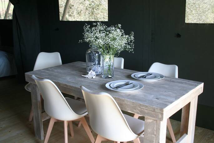 Five seated wooden dining table inside of Safari tent at Little Nook Glamping, Cornwall
