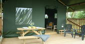View of decking from outside of Mobbs with bench and seating area at Little Nook Glamping, Cornwall