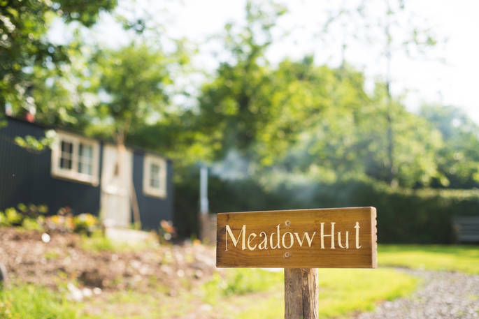Meadow hut wooden sign with the hut in the background