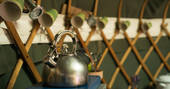 Kitchen kettle with cups hanging on wooden hooks