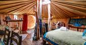 Looking from the back of the yurt over the comfy bed and interior space in Cornish Hobbit, Cornwall