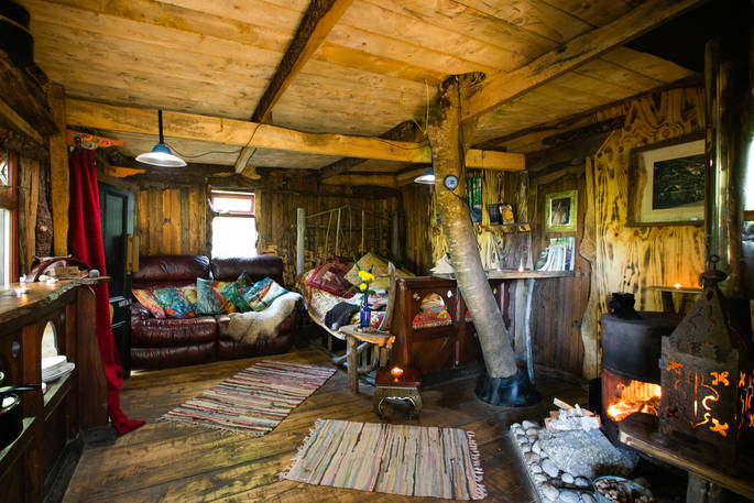 Inside Cornwall hobbit house at Mill Valley in Cornwall with woodburner filling the cosy cabin with warmth
