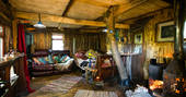 Inside Cornwall hobbit house at Mill Valley in Cornwall with woodburner filling the cosy cabin with warmth