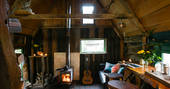 Interior of the lounge area and woodburner in Woodland Cabin at Mill Valley in Cornwall 