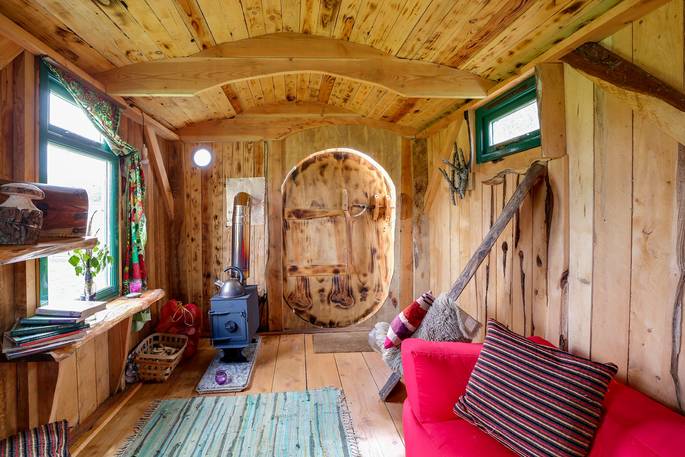 An interior view of the cosy wood crafted Woodland Hobbit cabin in Cornwall