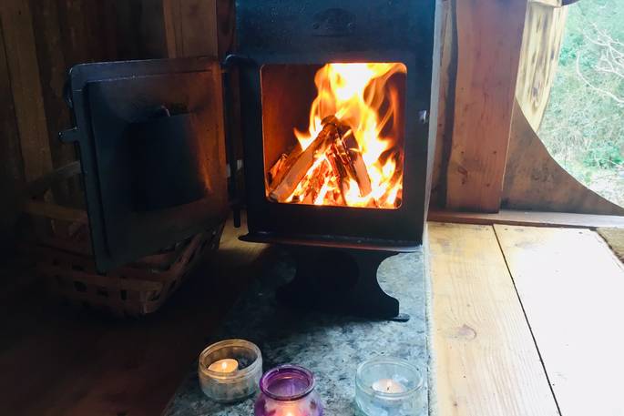 Interior of Woodland Hobbit with a roaring fire on at Mill Valley in Cornwall