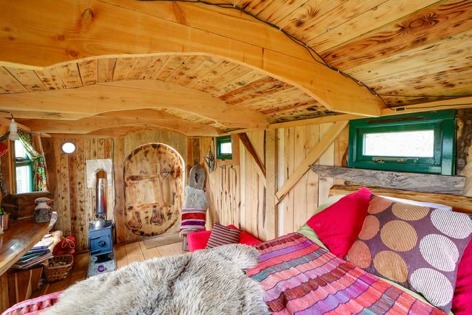 Sitting on the bed over the interior in the Woodland Hobbit in Cornwall
