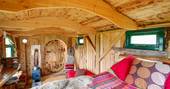 Sitting on the bed over the interior in the Woodland Hobbit in Cornwall