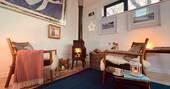 Living area with a dining table with seating for two and a wood burner