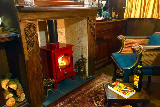 Sit by the fire with a glass of red wine at Sanger's Showman's Wagon in Cornwall