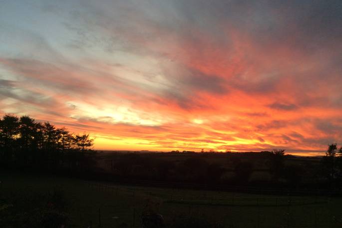 View of the burnt orange and pink sun set over the skies of Cornwall 