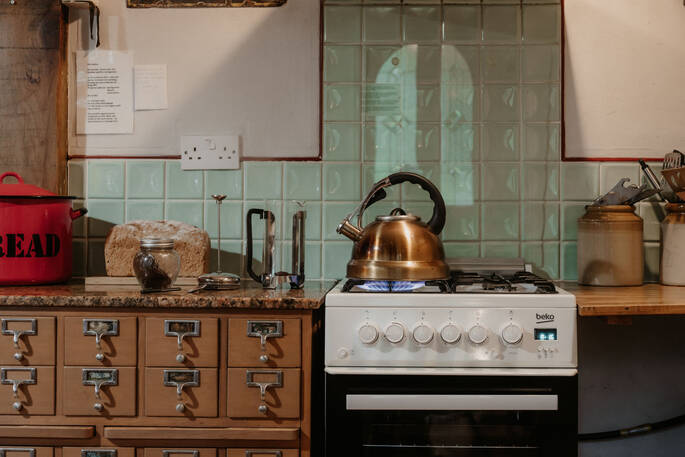 Kitchen equipped with an oven, stove, kettle, cooking utensils