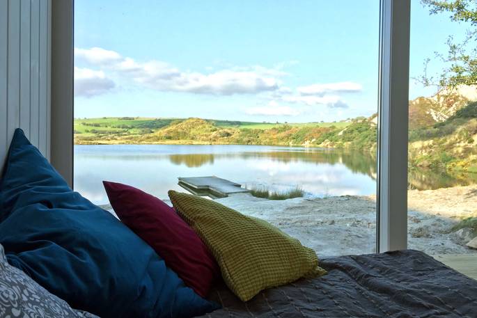view from the bed shipping container cabin private lake secluded cornish holiday 