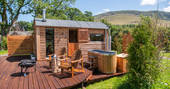 Decking area has a wood fired hot tub and a firepit area with seating for two