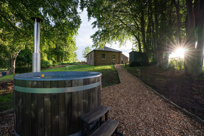 Cuckoo Cottage hot tub with view to the cottage, Edenhall Estate, Penrith, Cumbria