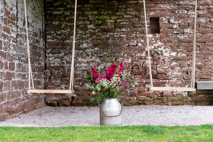 Two swings amongst traditional stone brick, at The Bothy at High Barn, in Cumbria