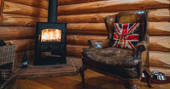 Relax in a comfy chair by the wood burner at The Lodge at Edenhall, Cumbria