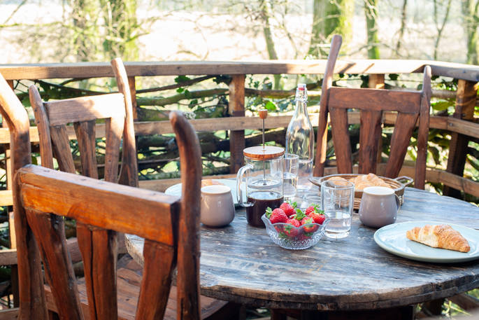 Dine al fresco and enjoy breakfast whilst looking over the river at Faraway Treehouse in Cumbria