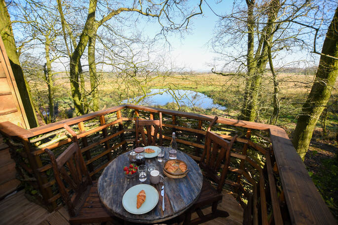 Dine al fresco and enjoy breakfast whilst looking over the river at Faraway Treehouse in Cumbria 
