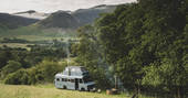 A converted bus, with a VW camper bedroom on the roof, in a remote corner of The Lake District
