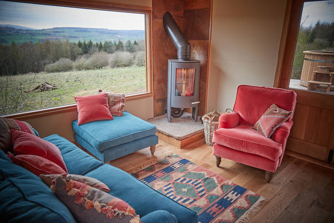 Silva Treehouse living room area with view and wood burner, Into the Woods. Penrith, Cumbria