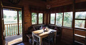 Inside the charming and rustic Netherby treehouse, with snug corner seating and dining table