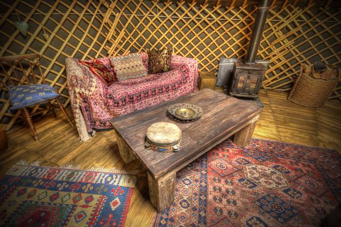 Sit and read by the cosy fire at Netherby Woodland Yurt in Cumbria