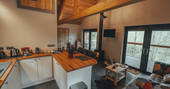 Edens Vale Lodge cabin interior with view and wood burner, River House, Penrith, Cumbria