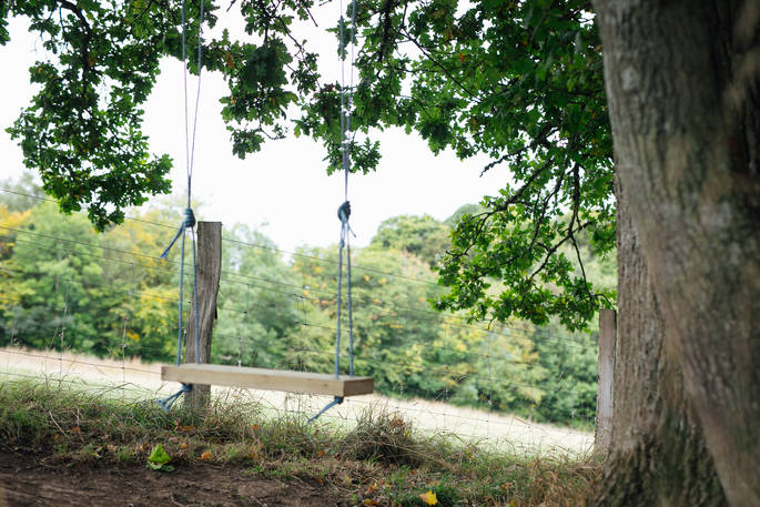 Play on the swing suspended from a tree at Acorn Farm