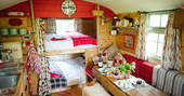 Two built in double bunk beds and bench inside of Fairfield at Acorn Farm in Devon