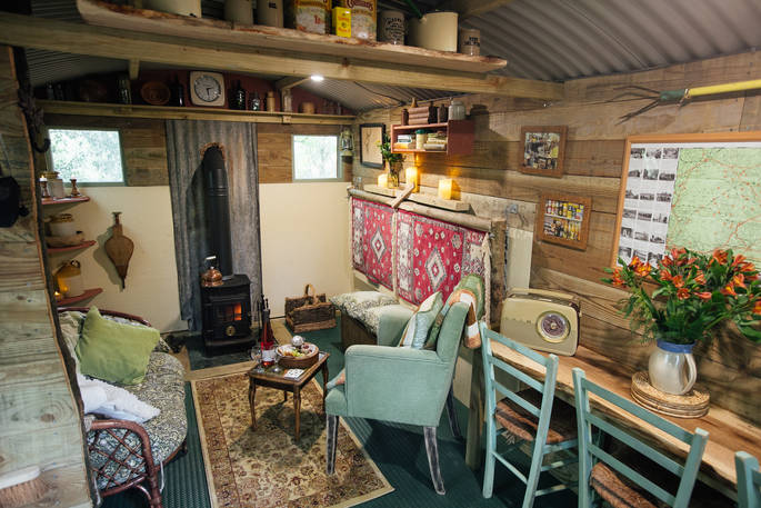 Cosy up by the wood-burner inside the shepherd's hut at Turners Woodland Suite at Acorn Farm in Devon