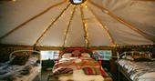 Inside the cosy and charming homemade yurt at Turners Woodland Suite, with comfortable double bed and two single beds