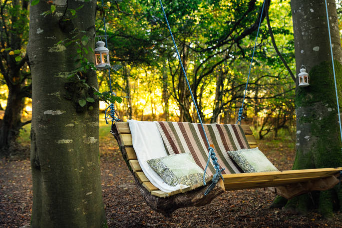 Swinging chair for two attached to the trees at Turners Woodland Suit at Acorn Farm in Devon