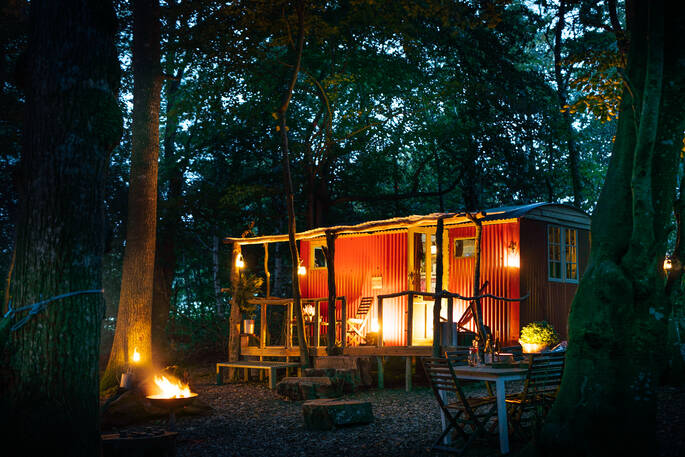 The burnt orange shepherd's hut at Turner's Woodland Suite, which houses a fully-equipped kitchen