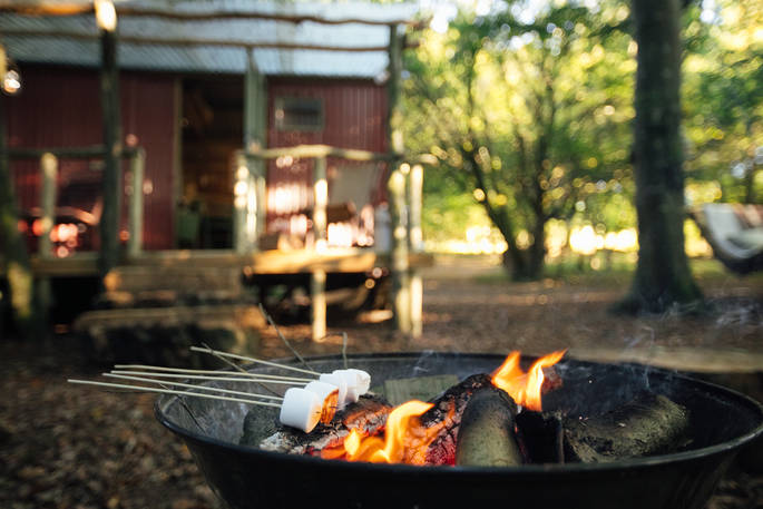 Toast marshmallows and enjoy them whilst sitting round the outdoor fire pit at Turners Woodland Suite in Devon