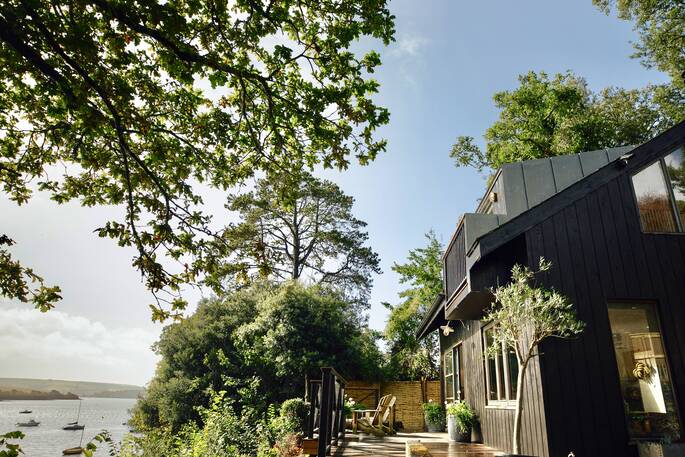 Sit on the balcony overlooking the water from Bowcombe Boathouse in Devon 