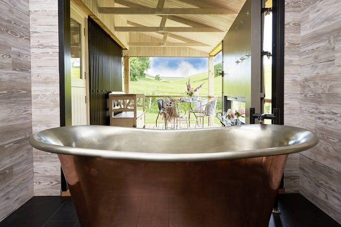 Open the doors to the outside deck and enjoy an al fresco bath experience from the copper tub with countryside views