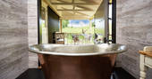 Open the doors to the outside deck and enjoy an al fresco bath experience from the copper tub with countryside views