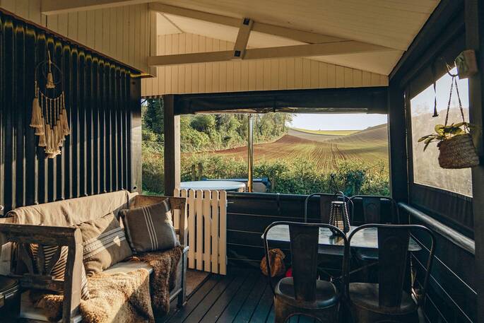 Sit on Brownscombe Cabin's covered outside deck to have breakfast with countryside views across the neighbouring barley fields