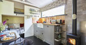 The woodburner roars in the cabin's fitted kitchen next to the cabin style kids bunk beds