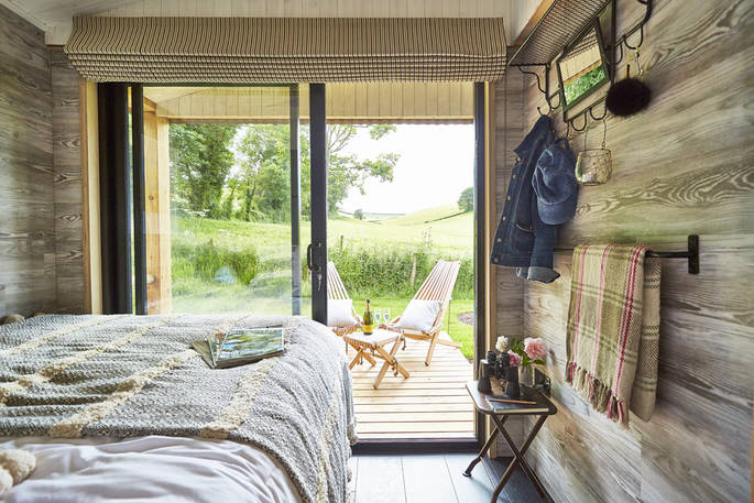 Views from the cabin's double bed of green fields at Brownscombe Luxury Glamping