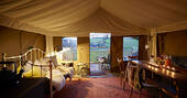 From out from interior of Dart safari tent of deck and rolling hills at Brownscombe at dusks