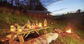 Dine al fresco around the safari tent's picnic table under open skies with a campfire feast