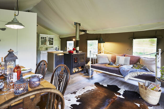 The beautifully fitted living space with kitchen and log burner at Tamar safari tent in Devon