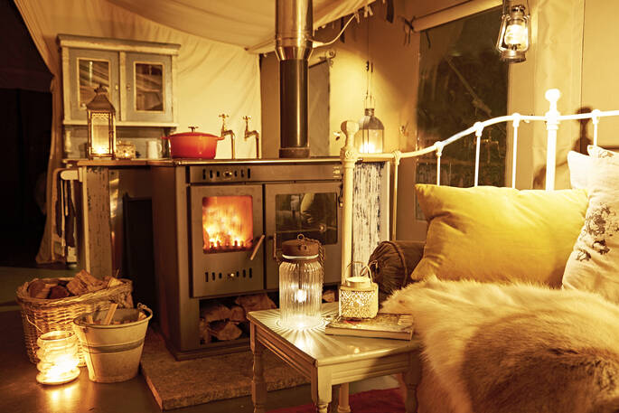 Settle in for the night with the woodburner roaring inside Yealm safari tent. Gather together as you listen out for owls hooting as darkness decends