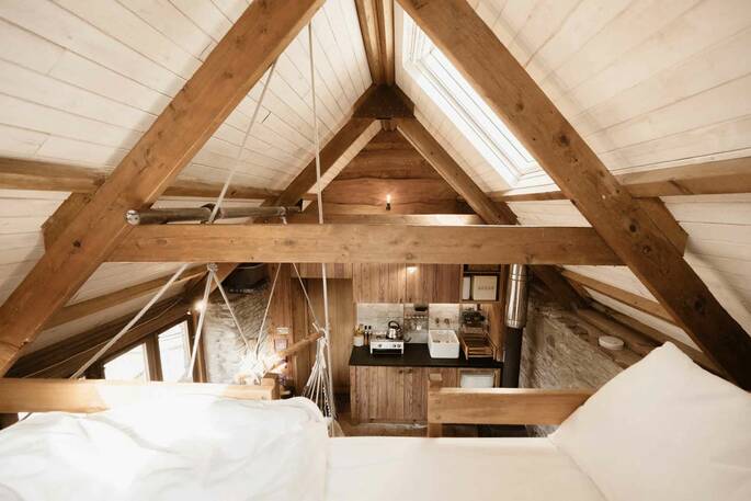 Double bed is up on a mezzanine accessable by a ladder