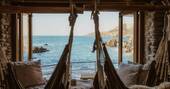 Relaxing swinging hammocks in in the living area with a view to the sea