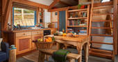 Dinner and a fruit and veg basket on the table inside Carpenter Cabin at Devon Dens