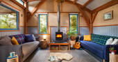 The cosy living room with a roaring log burner in Carpenter Cabin, Devon